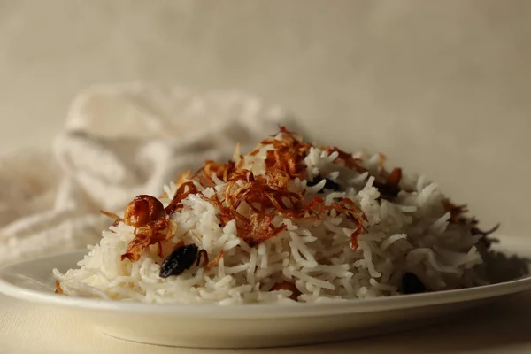Rice dish made of Basmati rice, ghee and spices and garnished with fried onions and cashews. Commonly known as Ney choru in Kerala. Shot on white background.