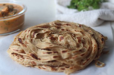 Parotta ya da Porotta, Maida 'dan yapılmış katmanlı bir ekmek. Bu sarkık kurdeleli krep Kerala 'nın favorisi. Tereyağlı tereyağlı tavukla tereyağlı kremalı domates sosunda pişirilmiş ızgara tavuk parçaları.