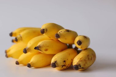 Beyaz bir yüzeye yerleştirilmiş olgun Lady Finger muzları, şeker muzları ya da Elaichi muzları olarak da bilinir. Küçük boy ve kahverengi noktalar olgunluğu gösteriyor. Hint mutfağında popüler tropikal meyve