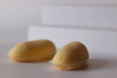 Beyaz bir yüzeyde muz aromalı yumuşak kremalı sünger içeren tek tek Japon muz kremalı keki sunulmaktadır. Yakın plan çekimler havadar dokuyu vurguluyor, Japonya 'da genellikle paketlenmiş tatlı olarak kullanılır.