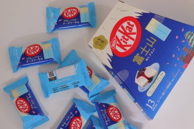 Tokyo, Japonya, 14 Aralık 2025: Fuji yabanmersinli cheesecake Dağı aromalı KitKat çikolatalı gofret parçaları ve perakende paketleme Japonya 'ya özel bölgesel hediyelik eşya ürünleri sergileniyor