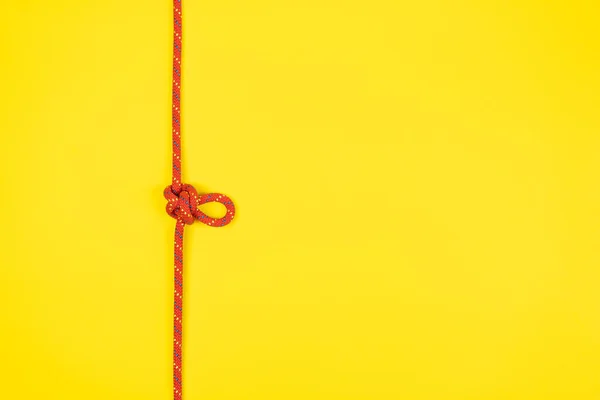 Узел Петли Бабочки Красной Альпинистской Веревкой Желтом Фоне — стоковое фото