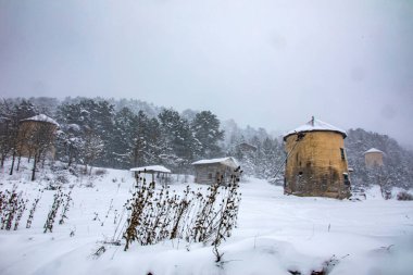 Karlı bir arazide çekilmiş bir yel değirmeni fotoğrafı. Dahası, bu fotoğraf hindiyi en güzel yerlerdeki salamuradan ayırmak için..
