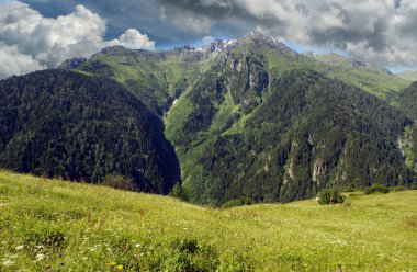 Dünya 'ya inen ve dağlara yayılan bulutların panoramik fotoğrafı. Bu manzara doğal elementlerin gerçekçi ve mükemmel uyumunu yansıtıyor ve mükemmel bir estetik yaratıyor..