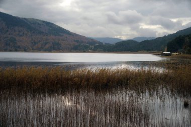 A close up shot of a view that captures the beautiful lake between the mountains. This scenery reflects the realistic and perfect harmony of natural elements.