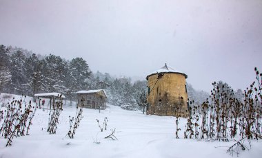 Karlı bir arazide çekilmiş bir yel değirmeni fotoğrafı. Dahası, bu fotoğraf hindiyi en güzel yerlerdeki salamuradan ayırmak için..