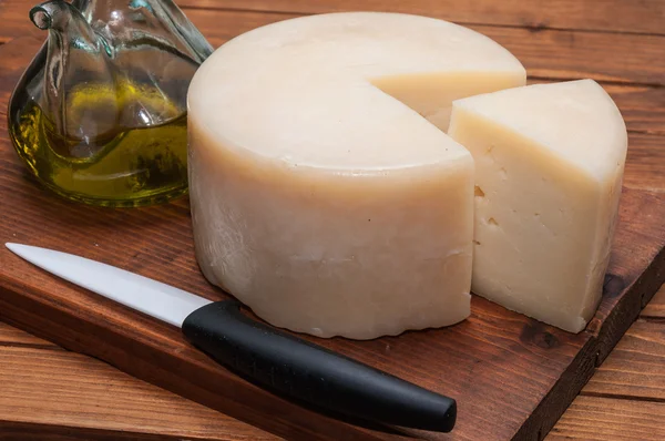 Queso con una rebanada y un cuchillo —  Fotos de Stock