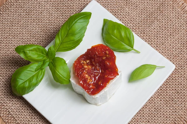Aperitivo de queso de cabra con tomates secos y albahaca —  Fotos de Stock