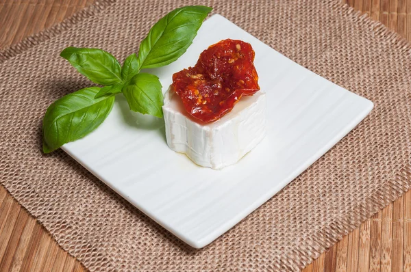 Aperitivo de queso de cabra con tomates secos y albahaca —  Fotos de Stock