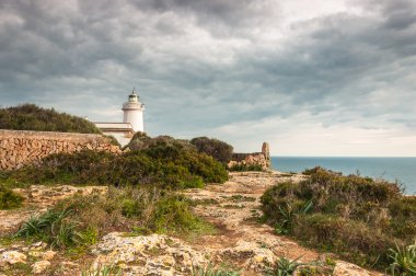 Bir deniz feneri ile fırtına günbatımı manzara