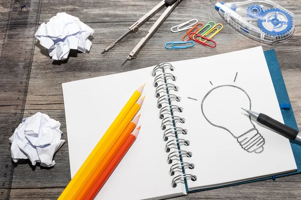 Drawing a bulb on a notepad — Stock Photo, Image