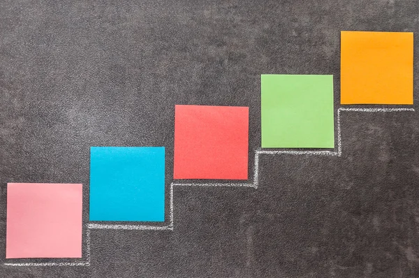 Boyalı bir merdiven bir tahta üzerine yerleştirilmiş renkli kağıt