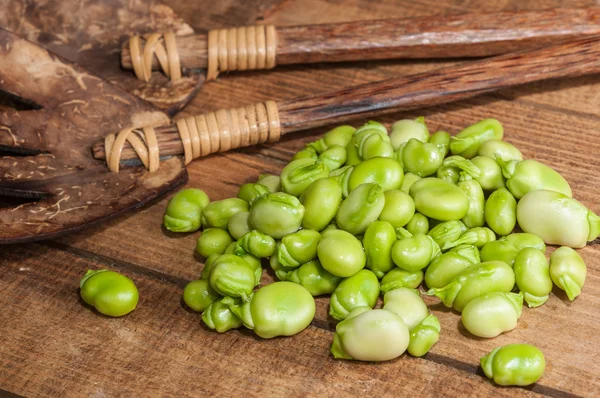 Çok ham fasulye ve ahşap bir tahta üzerinde rustik çatal bıçak takımı