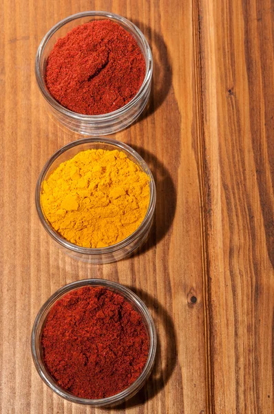 Three bowls with paprika and curry — Stock Photo, Image