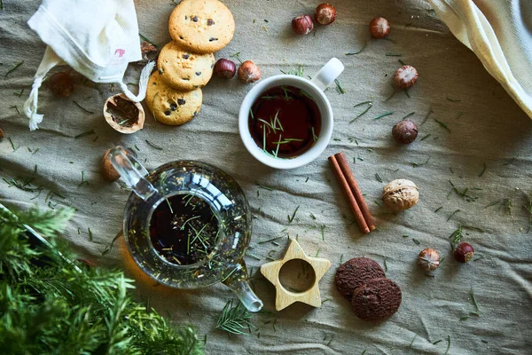 Lebkuchen, Früchtetee und Tannenzweige auf schwarzem Holzgrund. Weihnachts- und Neujahrsgenuss. — Stockfoto