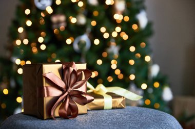 Yeni bir arkaplan için paketlenmiş hediyeler ve Noel kağıdı ile Noel ağacı ve şömine çelenklerinin arka planına karşı