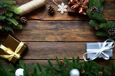 Noel ya da yeni yıl tatiline hazırlanıyorum. Düz kürk dalları, yemyeşil çelenkler, Noel hediyesi ahşap masa arkaplanı, üst manzara, kopyalama alanı.