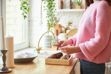 Bir kadın, aydınlık bir çatı katında Noel dekorasyonu yapar.