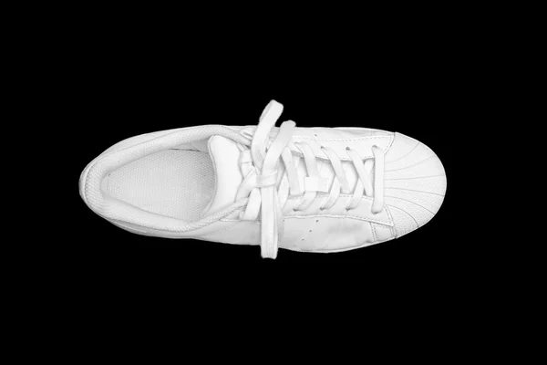 Witte sneakers geïsoleerd op zwarte achtergrond Stockafbeelding