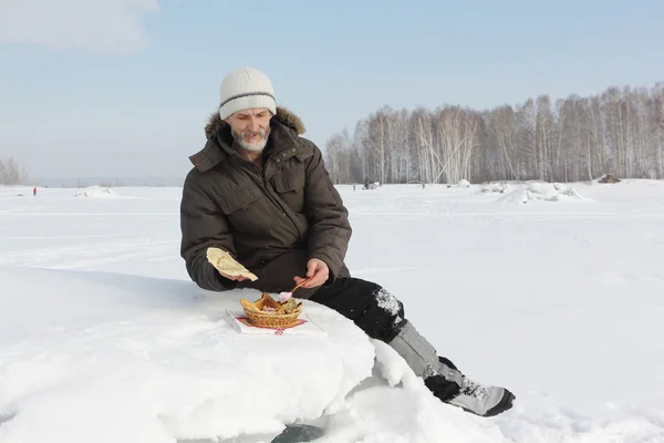 De man de reiziger met een baard eten scherpe pannenkoeken buitenshuis — Stockfoto