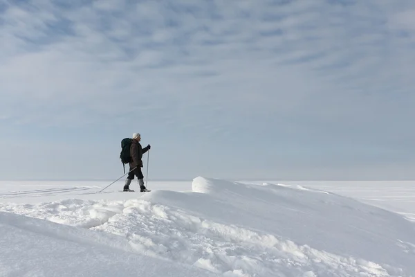 De man de reiziger met een rugzak skiën op sneeuw — Stockfoto