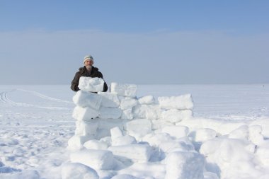 Kışın kar bloklar bir glade üzerinde bir Eskimo bina bir sakallı adam
