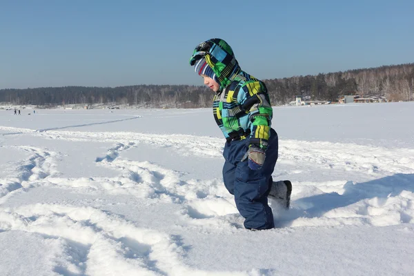 Dítě v bundě barvy běží na sněhu v zimě — Stock fotografie