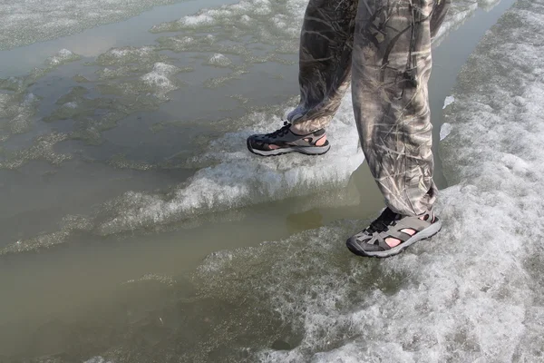 Male legs in sandals for rafting on ice of the thawing river — Stock Photo, Image