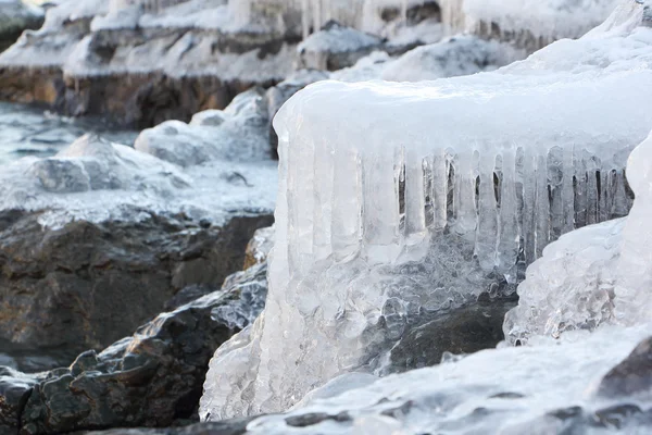 Icicles on stones at the thawing river in the spring — Stock Photo, Image