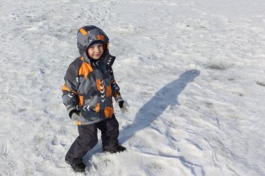 Kışın karda yürüyen küçük çocuk