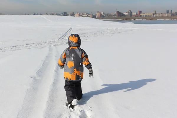 Mały chłopiec w kurtka koloru, spacery nad brzegiem śnieg — Zdjęcie stockowe