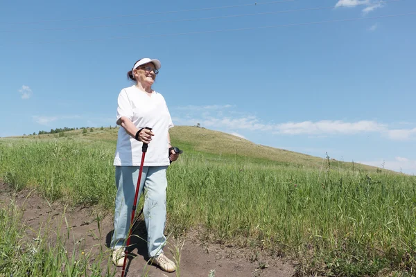 Nordic Walking - la donna anziana sta facendo escursioni — Foto Stock