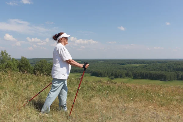 Nordic Walking - ηλικιωμένη γυναίκα είναι πεζοπορία το καλοκαίρι — Φωτογραφία Αρχείου