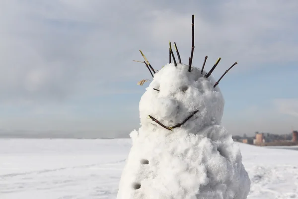 O boneco de neve incompleto alegre que está contra o céu — Fotografia de Stock