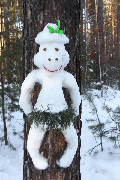 Boneco de neve em um tronco de pinheiro na forma de um macaco — Fotografia de Stock