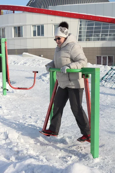 Die erwachsene Frau mit Sonnenbrille beim Gerätetraining — Stockfoto