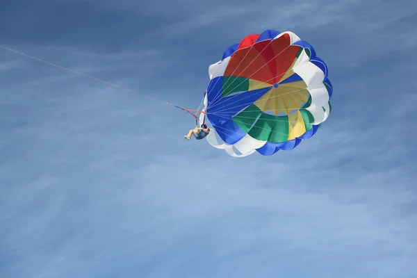 The person with a parachute on a cable flying in the blue sky — Stock Photo, Image