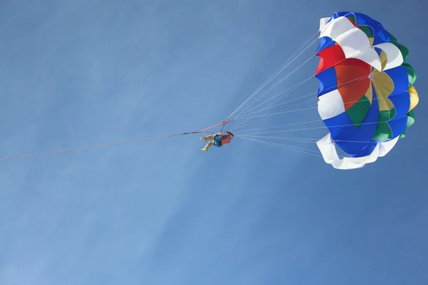 Die Person mit dem Fallschirm am Seil fliegt in den blauen Himmel — Stockfoto