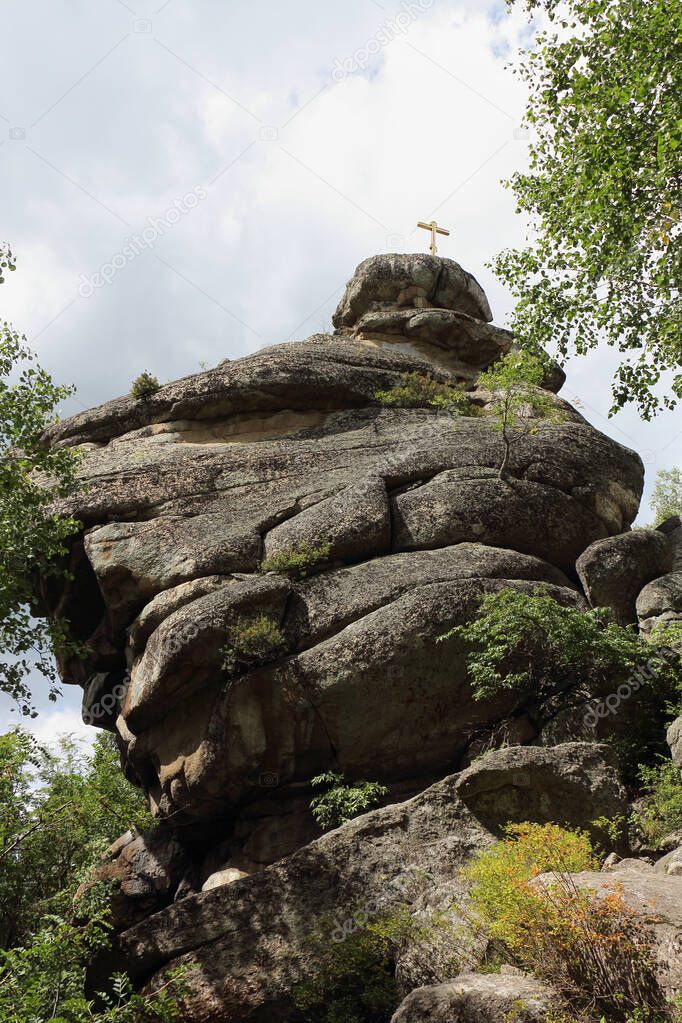 Rock with an Orthodox cross on the top of Mount Tserkovka, Altai Mountains, Belokurikha city, Russia