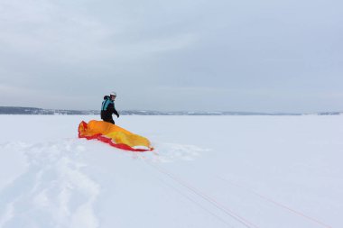 Kışın donmuş bir nehirde uçurtma eğitimi alan bir adam, Kama Reservoir, Perm City, Rusya