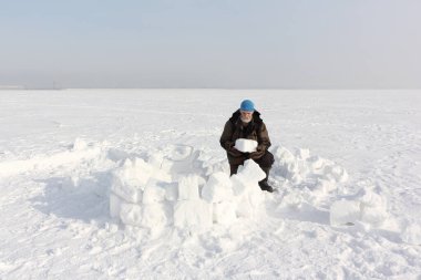 Kışın kar yığınlarından eskimo evi inşa eden adam, Ob rezervuarı, Novosibirsk, Rusya