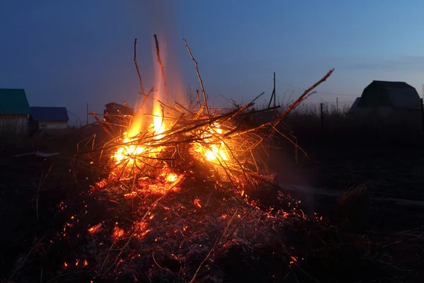 Fuego nocturno en la distancia de las casas contra el cielo — Foto de Stock