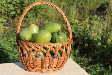 ' De bir tabloda bir gar gerdanlı sepet içinde yalan yeşil domates