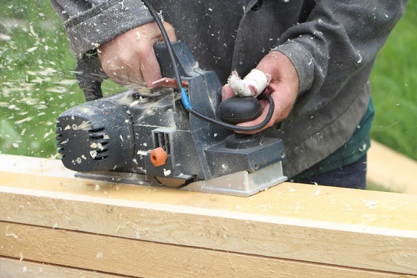Yaralı parmak adamla bir tahta jointer planı işler.