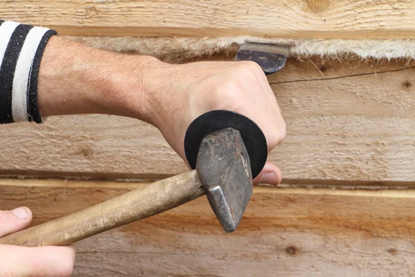 Male hands caulk a house wall from a bar — Stock Photo, Image