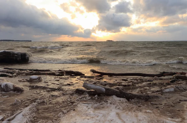 The running waves on the sandy snow-covered coast on a reservoir — Stock Photo, Image