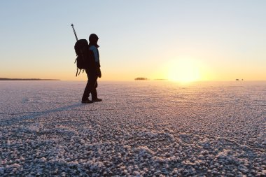 Adam buz Nehri üzerinde t gün batımında oluyor bir sırt çantası ile
