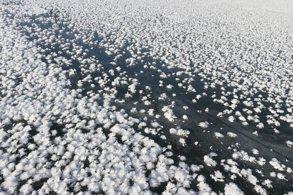 Rachadura em uma superfície de gelo do rio congelado, fundo natural — Fotografia de Stock