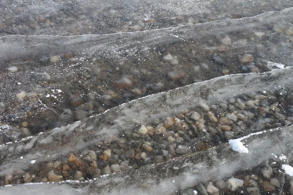 Praskliny v transparentní ledu na řece v zimě — Stock fotografie