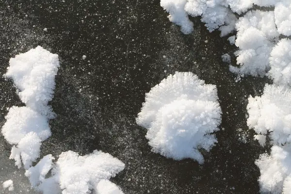 Schneelastige Auswüchse auf dem Eis des zugefrorenen Flusses — Stockfoto